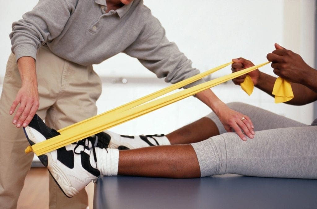 A person is being assisted by someone with a yellow band.