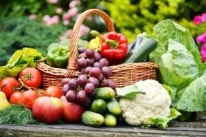 A basket of fruit and vegetables on top of a table.