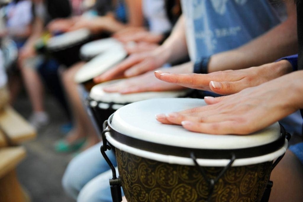 A group of people playing drums in front of a crowd.