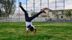 A person doing a handstand on the grass