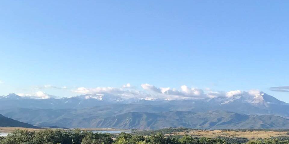 A view of the mountains from an open field.